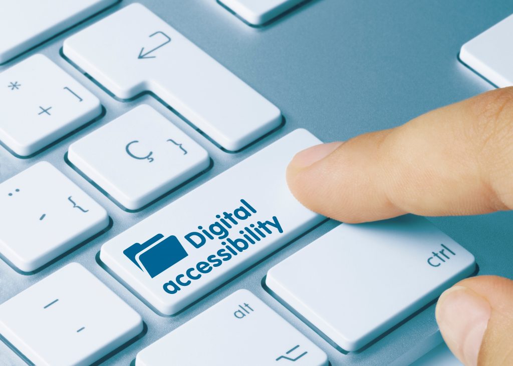 A close up of a finger pushing a key on a computer keyboard marked "Digital Accessibility".