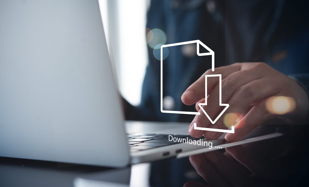 Close up of a person's hand downloading computer files or installing software on a laptop computer.