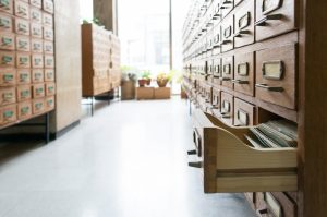 Old opened wooden card catalogue drawers in a library archive row.