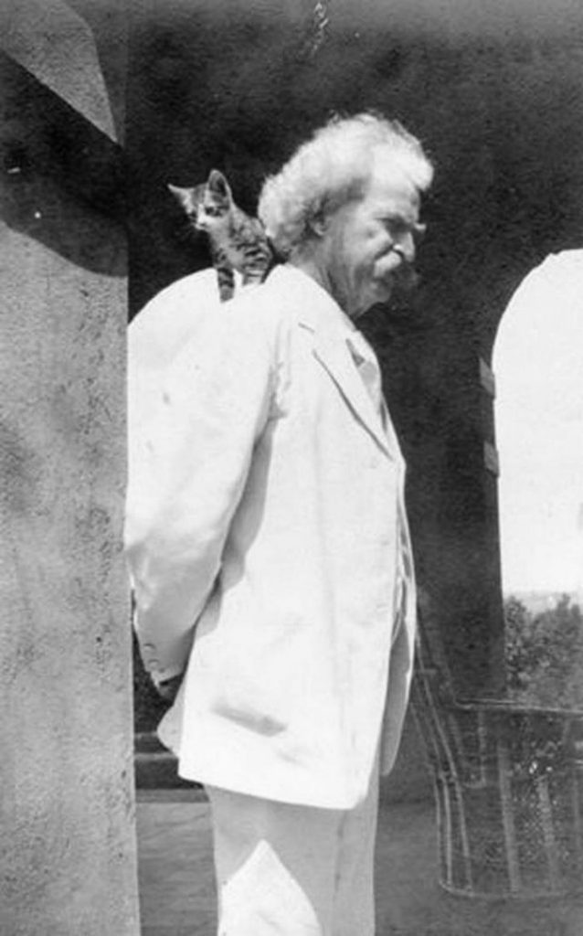 Author Mark Twain with a kitten on his shoulder.