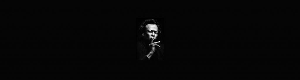 Jazz trumpeter Miles Davis on a black background.